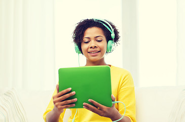 Image showing happy african woman with tablet pc and headphones