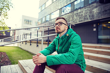 Image showing happy young hipster man sitting on stairs in city