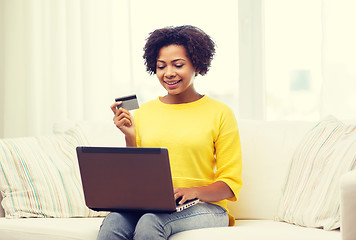 Image showing happy african woman with laptop and credit card