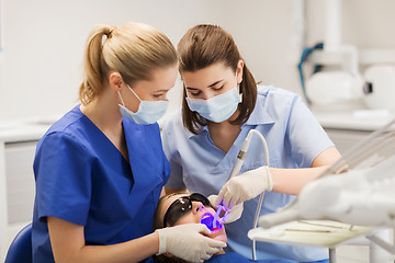 Image showing female dentists treating patient girl teeth