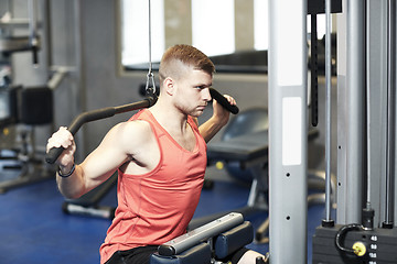 Image showing man flexing muscles on cable machine gym