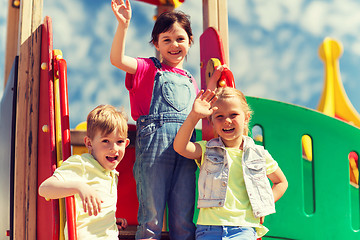 Image showing group of happy kids waving hands on playground