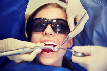 Image showing female dentists treating patient girl teeth