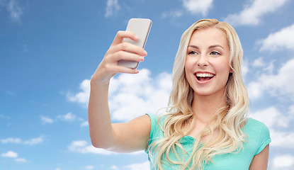 Image showing smiling young woman taking selfie with smartphone