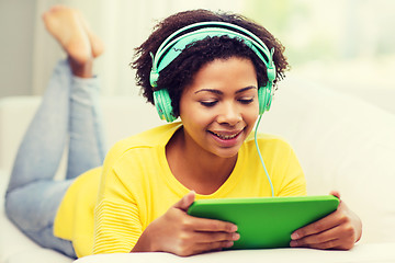 Image showing happy african woman with tablet pc and headphones