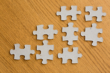 Image showing close up of puzzle pieces on wooden surface