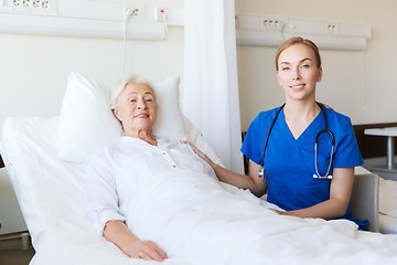 Image showing doctor or nurse visiting senior woman at hospital