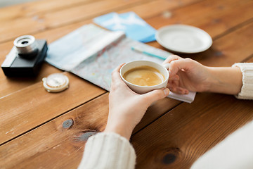 Image showing close up of hands with coffee cup and travel stuff