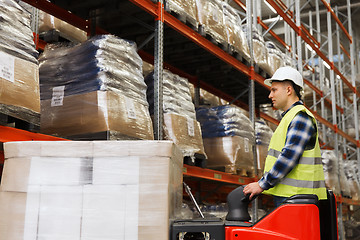 Image showing man on forklift loading cargo at warehouse