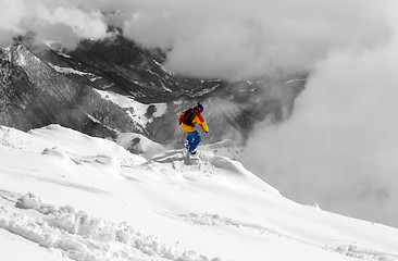 Image showing Snowboarder on off-piste slope an mountains in fog. Selective co