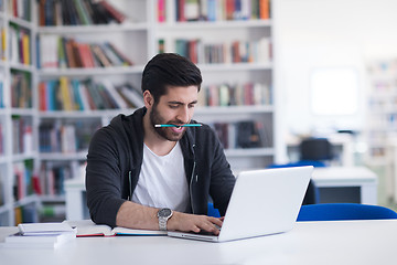 Image showing student in school library using laptop for research