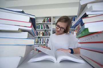 Image showing female student study in library, using tablet and searching for 