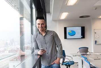 Image showing young business man using smart phone at office