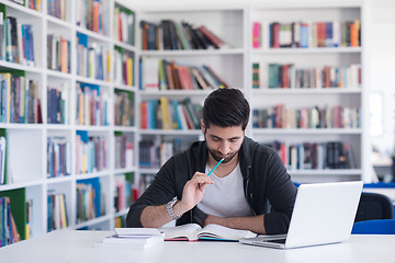 Image showing student in school library using laptop for research