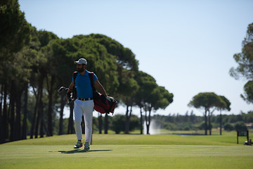 Image showing golf player walking and carrying bag