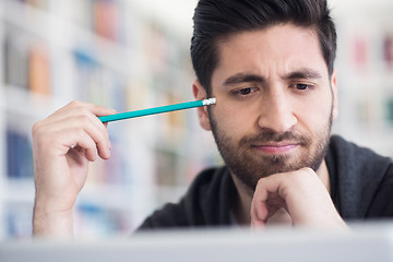 Image showing student in school library using laptop for research