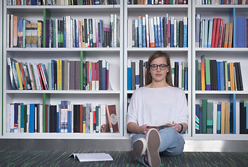 Image showing female student study in library, using tablet and searching for 