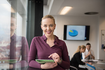 Image showing blonde businesswoman working on tablet at office