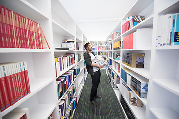 Image showing Student holding lot of books in school library