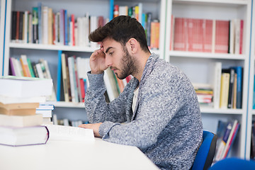 Image showing portrait of student while reading book  in school library