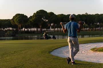 Image showing golfer from back at course looking to hole in distance