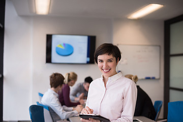 Image showing hispanic businesswoman with tablet at meeting room