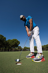 Image showing golf player hitting shot at sunny day, wide angle lens