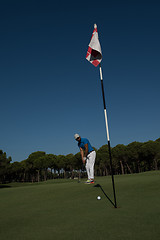 Image showing golf player hitting shot at sunny day