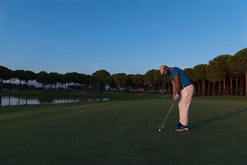 Image showing golfer  hitting shot at golf course