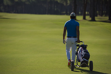 Image showing golf player walking with wheel bag