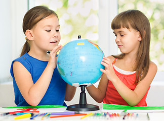 Image showing Little girls are examining globe