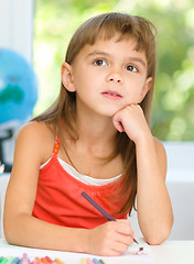 Image showing Little girl is drawing using pencils