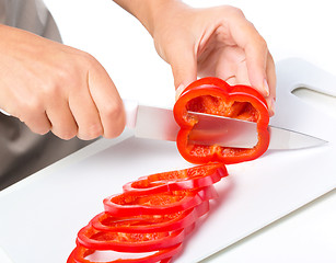 Image showing Cook is chopping bell pepper