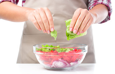 Image showing Cook is tearing lettuce while making salad