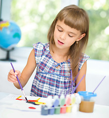 Image showing Little girl is painting with gouache