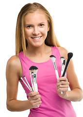 Image showing Teen girl is holding makeup brushes