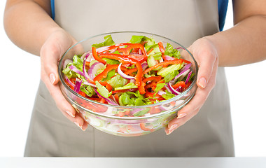 Image showing Cook is holding a big bowl with fresh salad