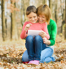 Image showing Mother and her daughter is playing with tablet