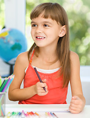 Image showing Little girl is drawing using pencils