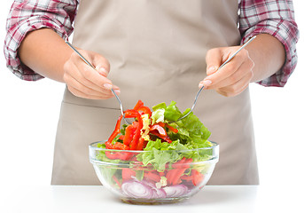 Image showing Cook is mixing salad