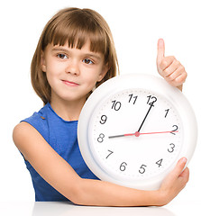 Image showing Little girl is holding big clock