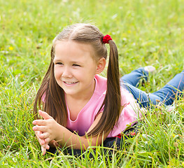 Image showing Portrait of a little girl laying on green grass