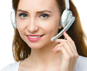 Image showing Lovely young woman is talking to customers