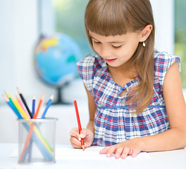 Image showing Little girl is drawing using pencils