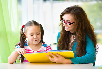 Image showing Mother is reading book with her daughter