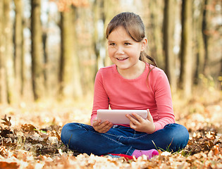 Image showing Little girl is reading from tablet