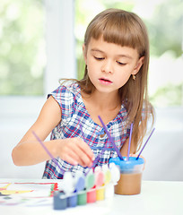 Image showing Little girl is painting with gouache