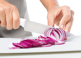 Image showing Cook is chopping onion