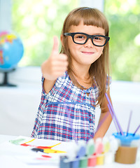 Image showing Little girl is painting with gouache