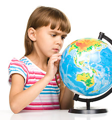 Image showing Little girl is examining globe